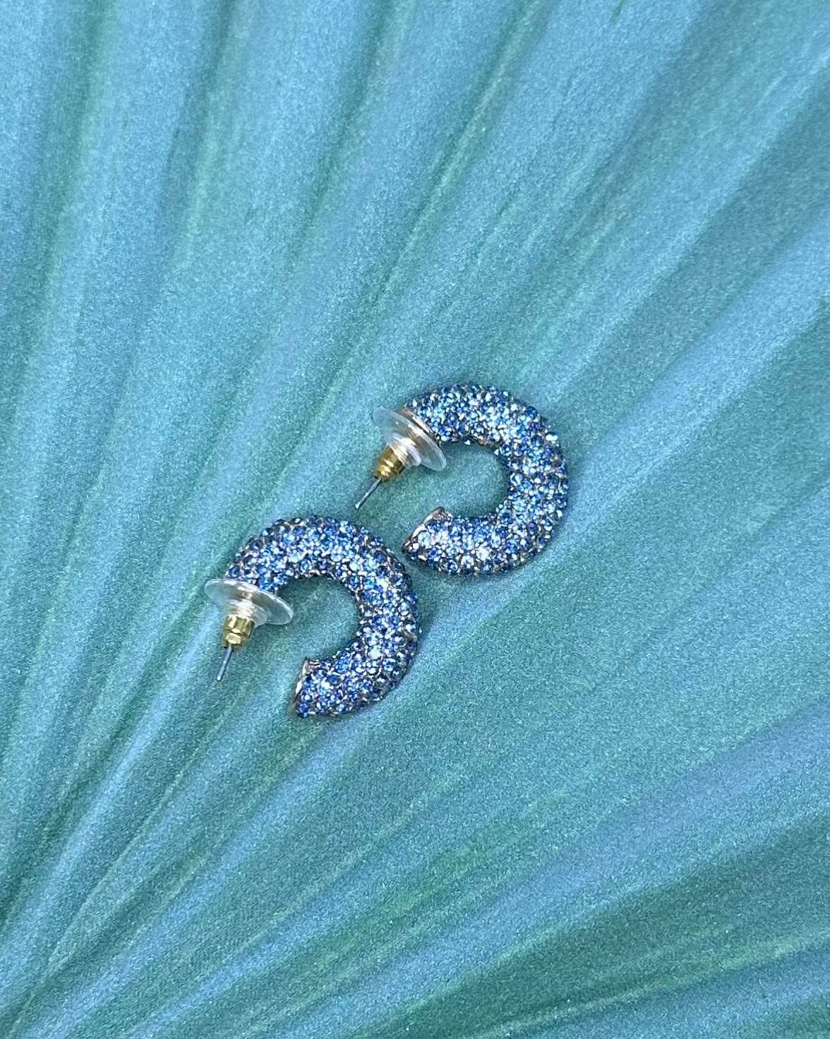 Close Up of Crystal Earrings on Blue Background